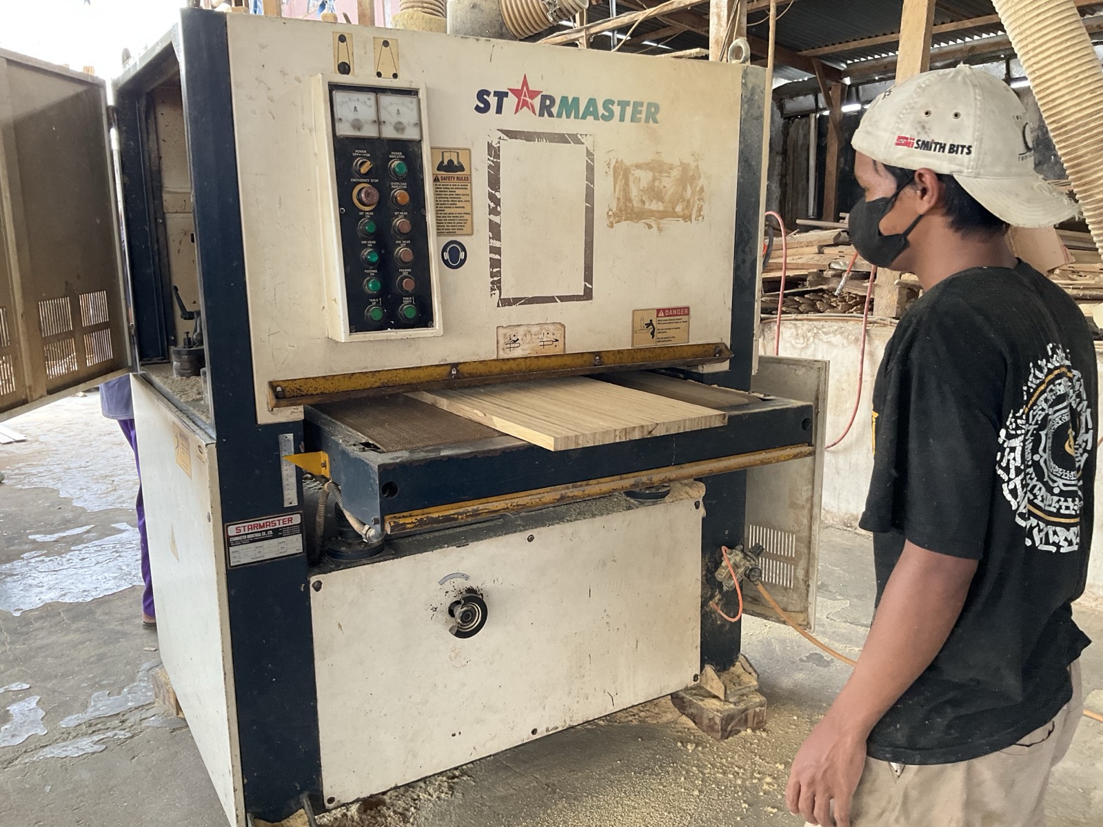 A laminated bamboo board passing through the wide-belt calibrating sander for an even thickness and smooth finish